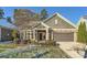 Gray-toned house with stone accents, two-car garage, and landscaped yard at 8235 Parknoll Dr, Huntersville, NC 28078