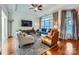 Spacious living room featuring hardwood floors, comfortable seating, and a large TV at 8235 Parknoll Dr, Huntersville, NC 28078