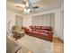Living room with leather couch, armchair, and ceiling fan at 504 N Pine Ln, Wadesboro, NC 28170