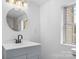 Updated bathroom with gray vanity, round mirror, and modern fixtures at 612 E E St, Newton, NC 28658