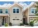 Tan two-story townhome with stone accents and a two-car garage at 14862 Tamarack Dr, Charlotte, NC 28278