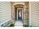 Inviting entryway with stone details and a dark brown front door at 14862 Tamarack Dr, Charlotte, NC 28278