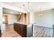 Kitchen island with granite countertop, dark cabinets, and view into living area at 14862 Tamarack Dr, Charlotte, NC 28278