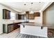 Modern kitchen with dark brown cabinets, granite island, and stainless steel appliances at 14862 Tamarack Dr, Charlotte, NC 28278