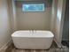 Modern bathroom with freestanding soaking tub and window at 51 Rosemont Dr, Stony Point, NC 28678