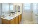 Bathroom with double vanity, wood cabinets, and tiled floor at 14446 Reese Blvd # 12, Huntersville, NC 28078