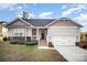 Charming one-story home with gray siding, stone accents, and a two-car garage at 159 Rubys Way # 35, Oakboro, NC 28129