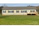 Beige single-story house with a wooden deck and a spacious lawn at 568 Drumstand Rd, Stony Point, NC 28678