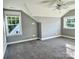 Well-lit bedroom featuring grey walls, carpet, and two large windows at 698 Lake Head Rd, Norwood, NC 28128