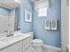 Clean bathroom with white vanity, shower, and light blue walls at 7315 Childress Sw Dr, Concord, NC 28025