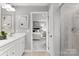 Main bathroom with double vanity, shower, and view into bedroom at 7329 Braswell Sw Dr, Concord, NC 28025