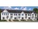 Image shows three-story townhouses with gray roofs and white siding at 7329 Braswell Sw Dr, Concord, NC 28025