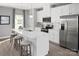 White kitchen with an island, stainless steel appliances, and white quartz countertops at 7329 Braswell Sw Dr, Concord, NC 28025
