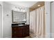 Bathroom with dark vanity, large mirror, and shower/tub combo at 907 Southwest Dr, Davidson, NC 28036