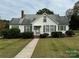 White house with green bushes, walkway, and carport at 1716 3Rd Ne St, Hickory, NC 28601
