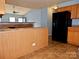 Kitchen features wood cabinets, black appliances, and an island counter at 7374 Sun Dance Dr, Fort Mill, SC 29707