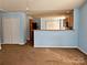 Open living space with a view into the kitchen, light blue walls, and brown carpet at 7374 Sun Dance Dr, Fort Mill, SC 29707