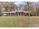 Brick ranch house with a white roof, columns, and landscaping; greenhouse visible at 16695 Silver Rd, Oakboro, NC 28129