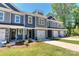 Three-unit townhome building, gray and blue exterior, two-car garages at 30 Woodsdale Se Pl, Concord, NC 28025