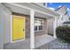 Covered front porch with stone accents and a yellow front door at 6058 Benedict Pl, Fort Mill, SC 29707