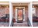 Brick front porch with two wicker chairs and a glass front door at 157 Montibello Dr, Mooresville, NC 28117