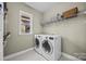 Bright laundry room with washer, dryer, and ample shelving at 157 Montibello Dr, Mooresville, NC 28117