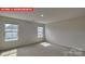 Well-lit bedroom with two windows and carpeted floor at 8000 Kennesaw Dr, Gastonia, NC 28056