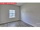 Simple bedroom with wood-look floors and a window at 8000 Kennesaw Dr, Gastonia, NC 28056