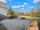 Large backyard with firepit, gravel patio, and mature trees at 922 Clover Park Dr, Clover, SC 29710