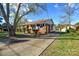 Brick ranch house with a large tree, driveway, and well-maintained lawn at 9313 Trinity Rd, Charlotte, NC 28216