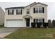 Two-story house with beige vinyl siding, a white garage door, and a well-maintained lawn at 9435 Bayview Pkwy # 91, Charlotte, NC 28216