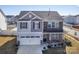 Charming two-story home with a gray and stone exterior, white garage door, and landscaped yard at 7607 Nolen Farm Dr, Gastonia, NC 28056