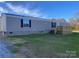 Single-wide manufactured home with a deck and grassy yard at 100 Debby Dr, Shelby, NC 28152