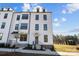 Three-story townhome with gray door and white siding at 13016 Moon Rd # 46, Charlotte, NC 28277