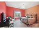 Bedroom with coral and peach walls, a window with a wooded view and a wrought iron bed frame at 226 Hermance Ln, Mooresville, NC 28117