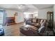 Living room with a fireplace, leather sectional sofa, and wood-look floors at 2506 River Chase Dr, Monroe, NC 28110