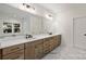 Double vanity bathroom with marble floors and a large mirror at 4918 Buckingham Dr, Charlotte, NC 28209