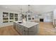 Open kitchen and living room with light hardwood floors and a large island at 4918 Buckingham Dr, Charlotte, NC 28209