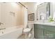 Clean bathroom with a bathtub, toilet and green vanity at 628 Kenlough Dr, Charlotte, NC 28209