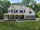 Two-story house with wrap around porch and stone accents at Lot 47 Watercourse Way # Devonshire, Belmont, NC 28012