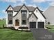 Two-story house with stone accents and a three-car garage at Lot 47 Watercourse Way # Devonshire, Belmont, NC 28012