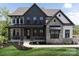 Two-story farmhouse with gray siding, stone accents, and a metal roof at Lot 42 Watercourse Way # Hawthorne, Belmont, NC 28012
