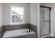 Simple bathroom with a built-in tub and a sliding glass shower door at Lot 51 Watercourse Way # Covington, Belmont, NC 28012