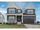 Two-story home with navy blue siding, white accents, and a two-car garage at Lot 51 Watercourse Way # Covington, Belmont, NC 28012