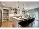 Modern kitchen boasting an expansive island, light gray cabinets, and stainless steel appliances at Lot 51 Watercourse Way # Covington, Belmont, NC 28012