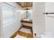 Modern bathroom with floating vanity, wood-look tile, and a window at 128 Wickford Ln, Mooresville, NC 28117