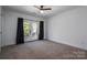 Bright bedroom with carpet flooring, double doors to balcony, and ceiling fan at 1511 Farm Rd, Shelby, NC 28152