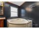 Bathroom with corner bathtub and window at 227 Grassy Meadow Ln, Statesville, NC 28625