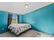 Bedroom with blue walls and floral bedding at 227 Grassy Meadow Ln, Statesville, NC 28625