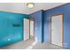 Well-lit bedroom with teal and blue walls, carpet flooring, and built-in shelving at 227 Grassy Meadow Ln, Statesville, NC 28625